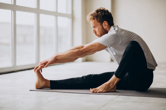 Jeune homme s'étirant sur un tapis de yoga