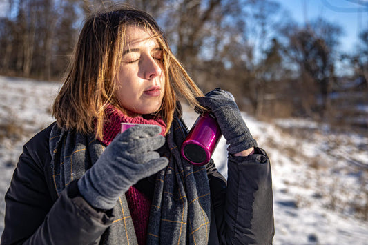 Jeune femme face au soleil en montagne 